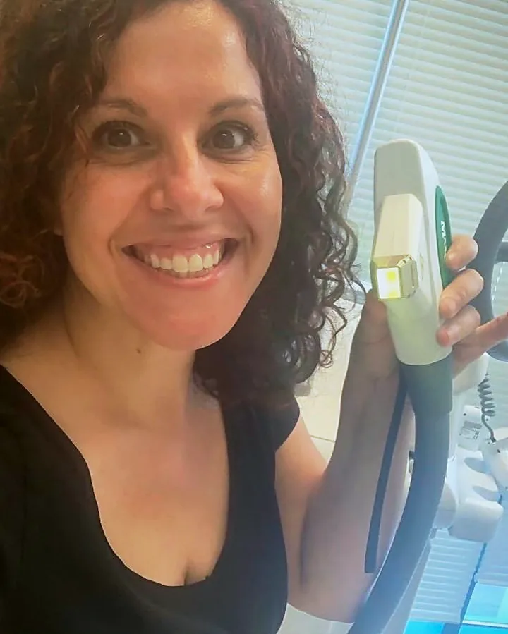 Rita Moldovanos, owner of Pure Light Laser, holding the laser handpiece